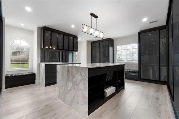 a kitchen with stainless steel appliances granite countertop a refrigerator a oven and a wooden floors