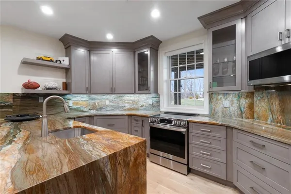 a kitchen with stainless steel appliances granite countertop a sink and a stove