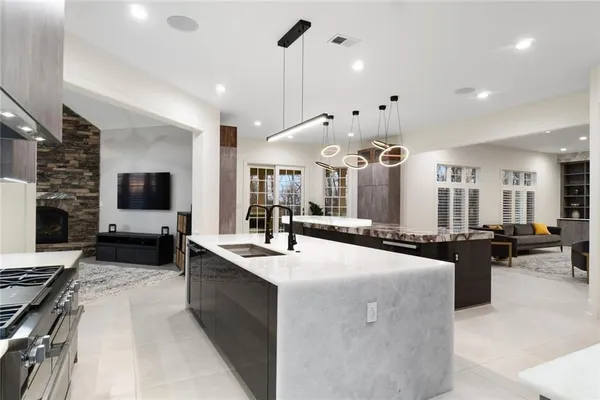 a large white kitchen with a large island in the center