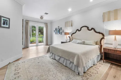 a spacious bedroom with a bed and a mirror on the dresser
