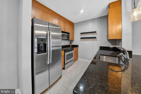 a kitchen with granite countertop a refrigerator and a sink