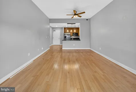 a view of a room with wooden floor and a ceiling fan