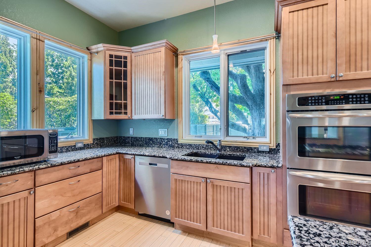 2895 South Cook Street Denver, CO 80210 - Photo 11 of 41 a kitchen with granite countertop a stove a sink and a microwave