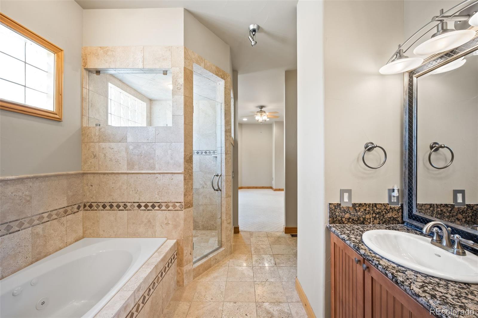 2895 South Cook Street Denver, CO 80210 - Photo 18 of 41 a bathroom with a granite countertop tub sink and mirror