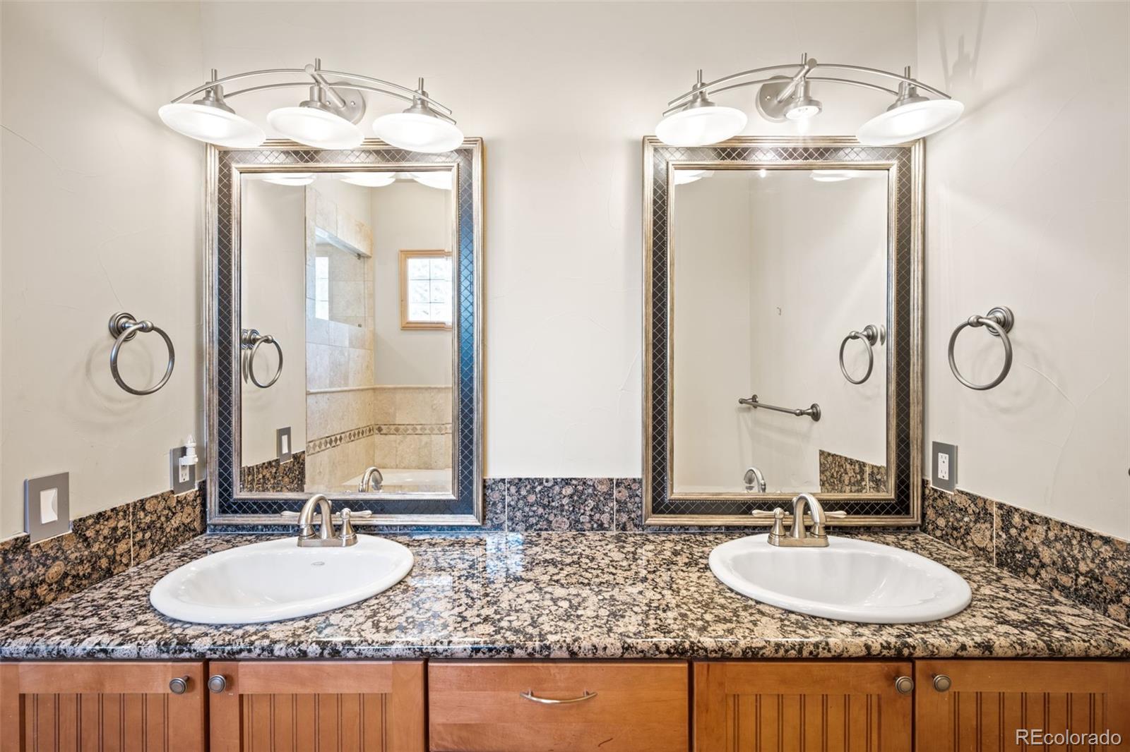 2895 South Cook Street Denver, CO 80210 - Photo 19 of 41 a bathroom with double vanity sinks granite vanity and a mirror