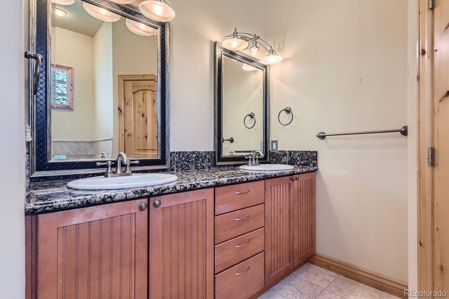 2895 South Cook Street Denver, CO 80210 - Photo 26 of 41 a bathroom with a granite countertop sink and a mirror