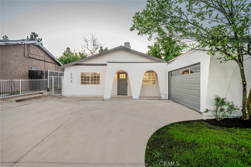 555 North Chestnut Avenue Rialto, CA 92376 - Photo 2 of 33 a view of a white house next to a yard and a large tree
