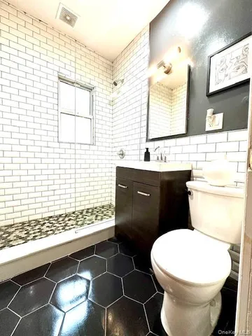 a bathroom with a toilet sink vanity and mirror