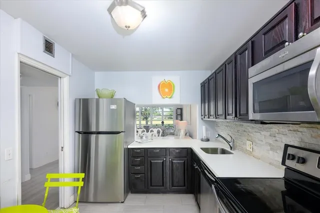 a kitchen with refrigerator and cabinets