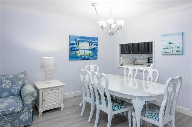 a dining room with furniture a chandelier and wooden floor