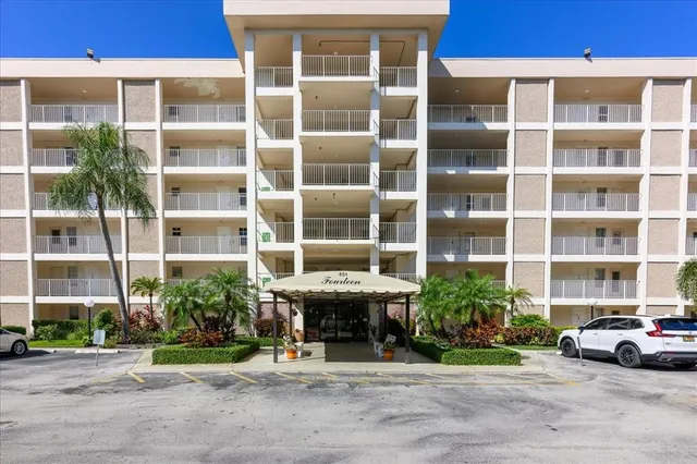 a front view of a building with a garden and plants
