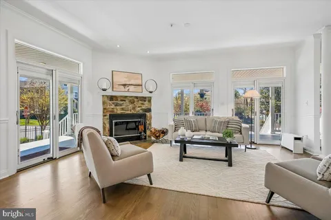 a living room with furniture a large window and a fireplace