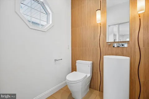 a white toilet sitting next to a bathroom sink and vanity