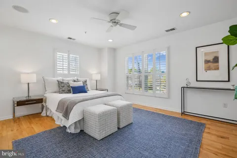 a spacious bedroom with a bed and wooden floor