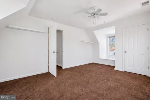 an empty room with fan and windows