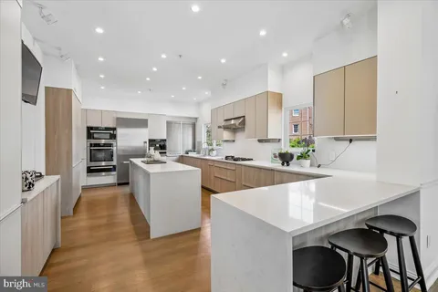 a room with stainless steel appliances kitchen island a table and chairs in it