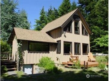 5221 Southwest Point Robinson Road Vashon, WA 98070 - Photo 1 of 1 a front view of a house with a yard table and chairs