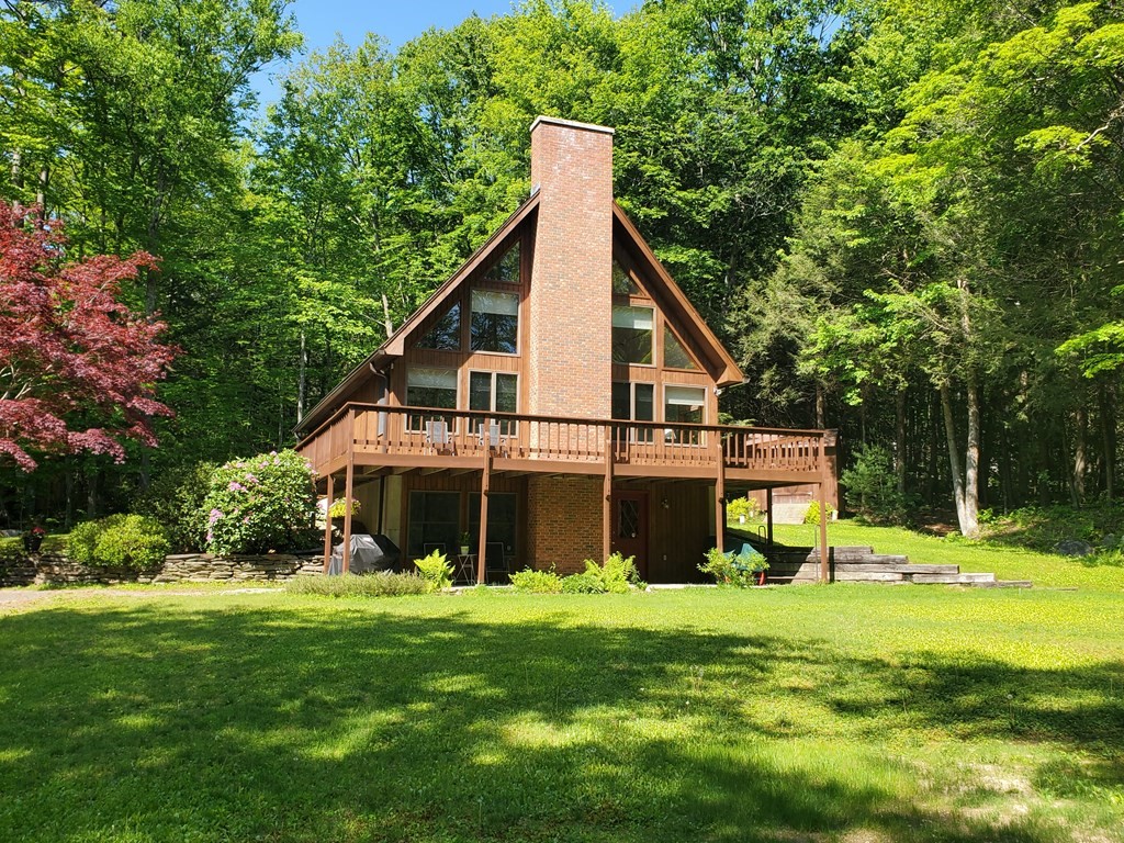 a view of a house with a yard and sitting area