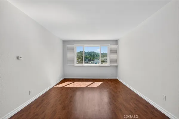a view of a room with wooden floor and window