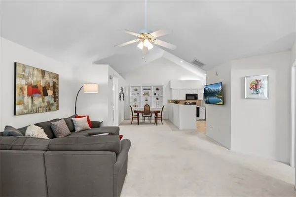 a living room with furniture and kitchen view