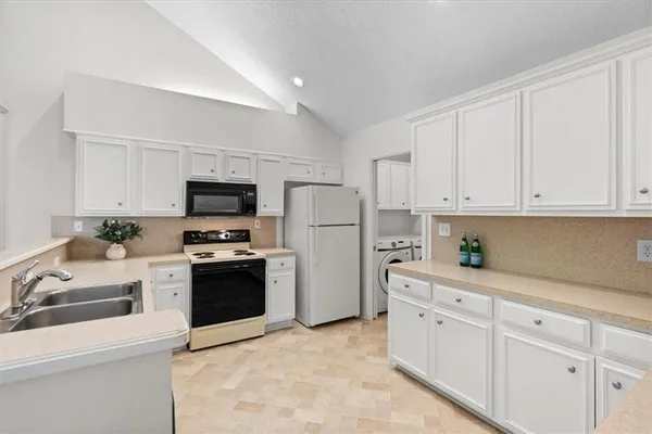 a kitchen with cabinets stainless steel appliances and sink