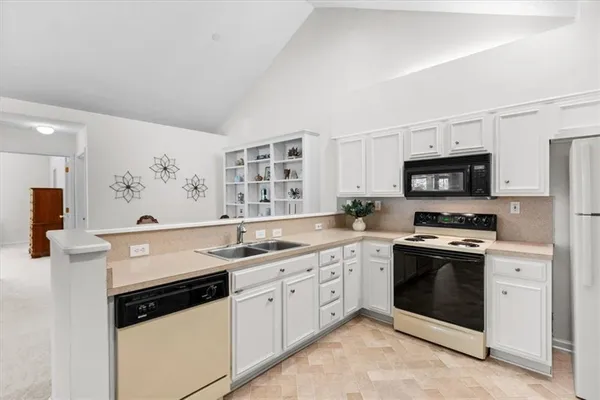 a kitchen with granite countertop a sink and white cabinets