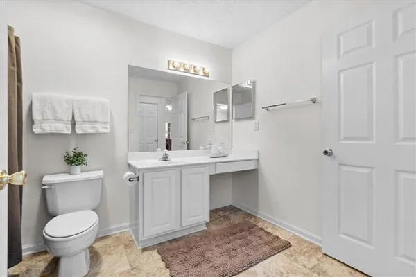 a bathroom with a sink toilet and a mirror