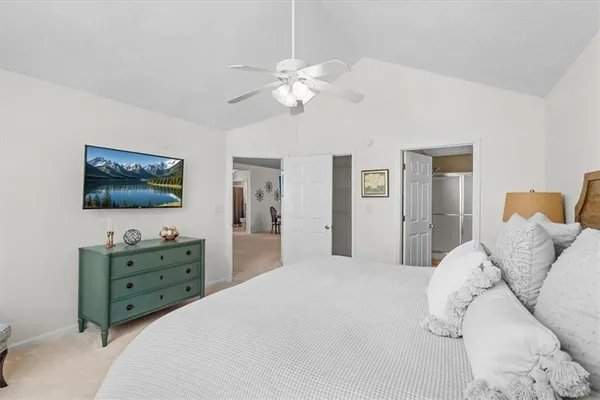 a bedroom with a bed a dresser and flat screen tv