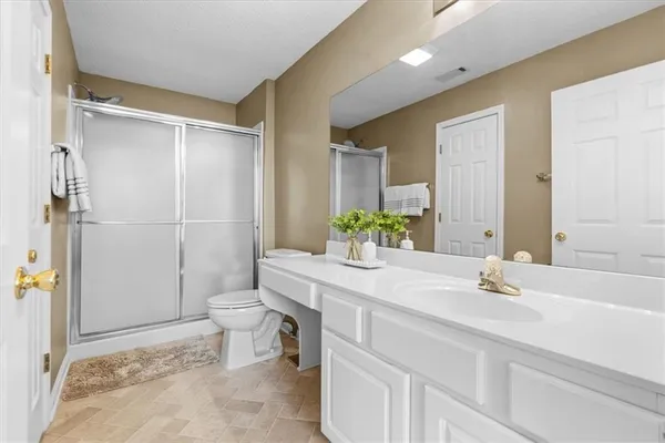 a bathroom with a granite countertop sink toilet and shower