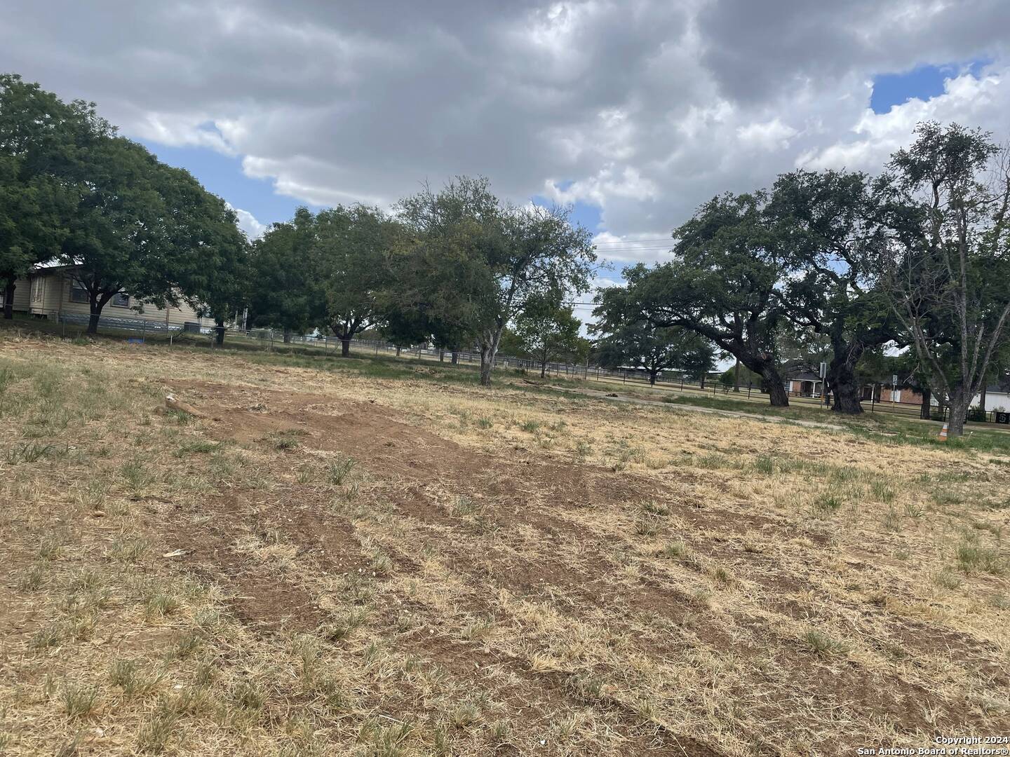 1405 West Goodwin Street Pleasanton, TX 78064 - Photo 2 of 6 a view of a yard with trees