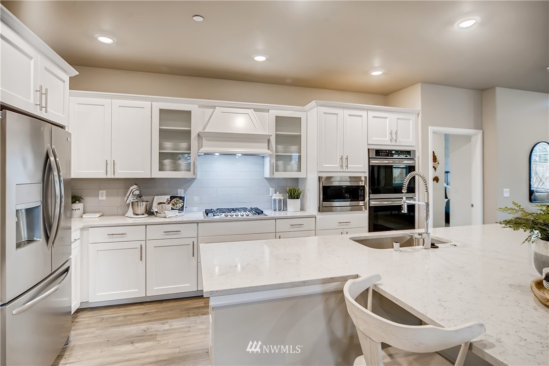 8812 Northeast 199th Street, Unit 1 Bothell, WA 98011 - Photo 2 of 31 a kitchen with stainless steel appliances kitchen island granite countertop a sink and cabinets