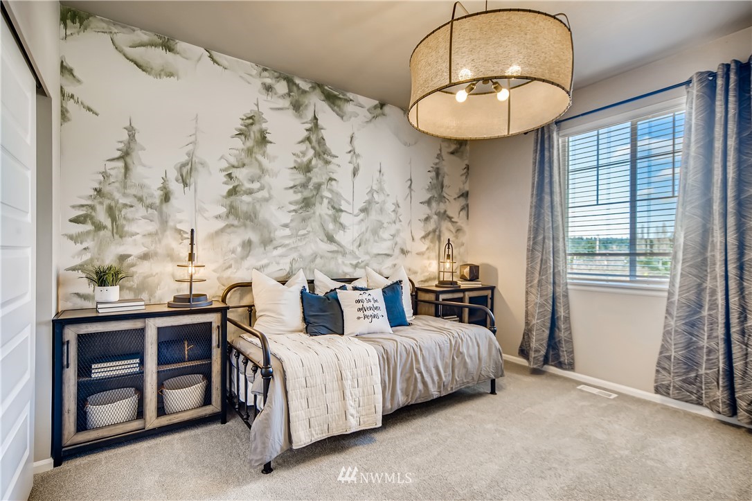 8812 Northeast 199th Street, Unit 1 Bothell, WA 98011 - Photo 18 of 31 a spacious bedroom with bed and a chandelier