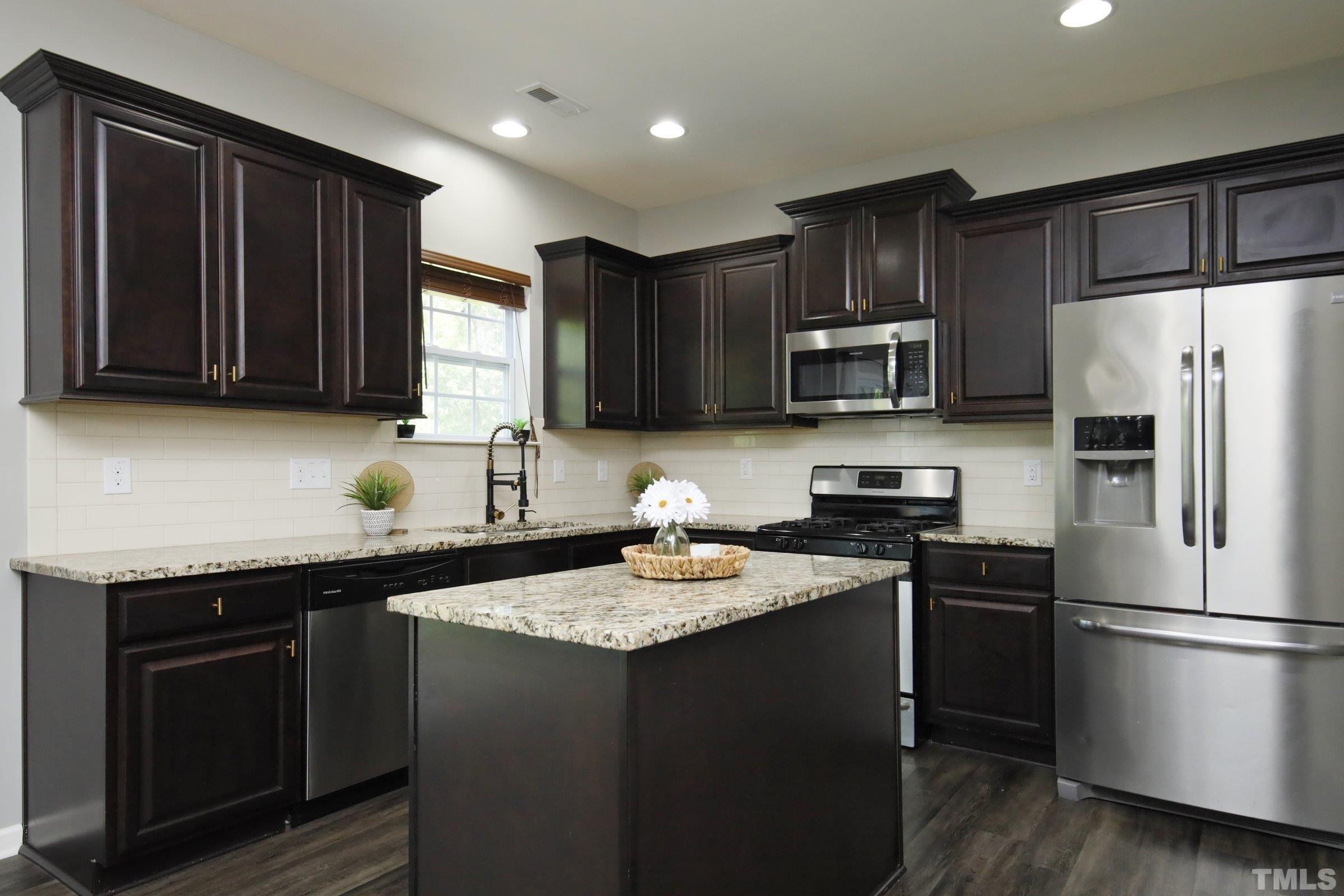 3617 Waleback Lane Raleigh, NC 27610 - Photo 13 of 34 a kitchen with a sink stove a refrigerator and a microwave