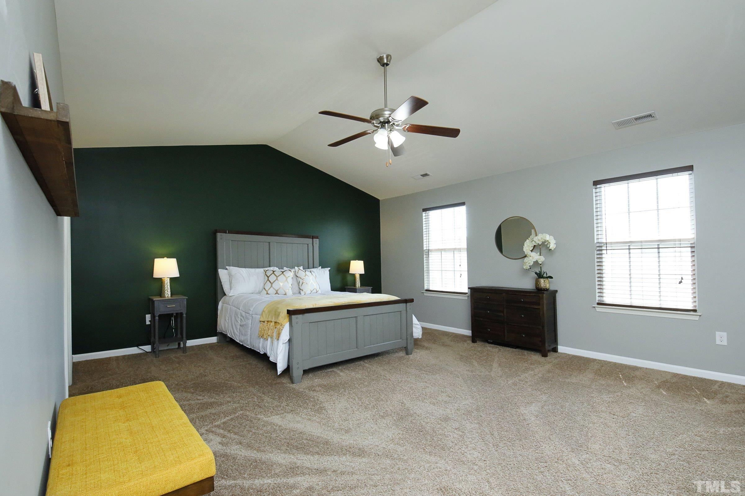 3617 Waleback Lane Raleigh, NC 27610 - Photo 20 of 34 a spacious bedroom with a bed and a chandelier