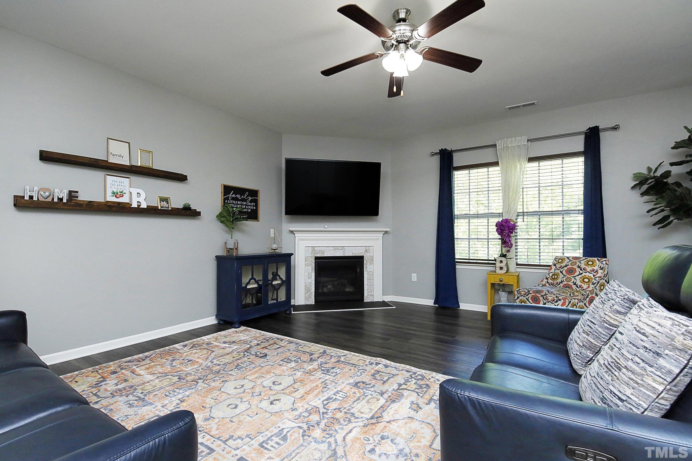 3617 Waleback Lane Raleigh, NC 27610 - Photo 9 of 34 a living room with furniture a fireplace and a flat screen tv