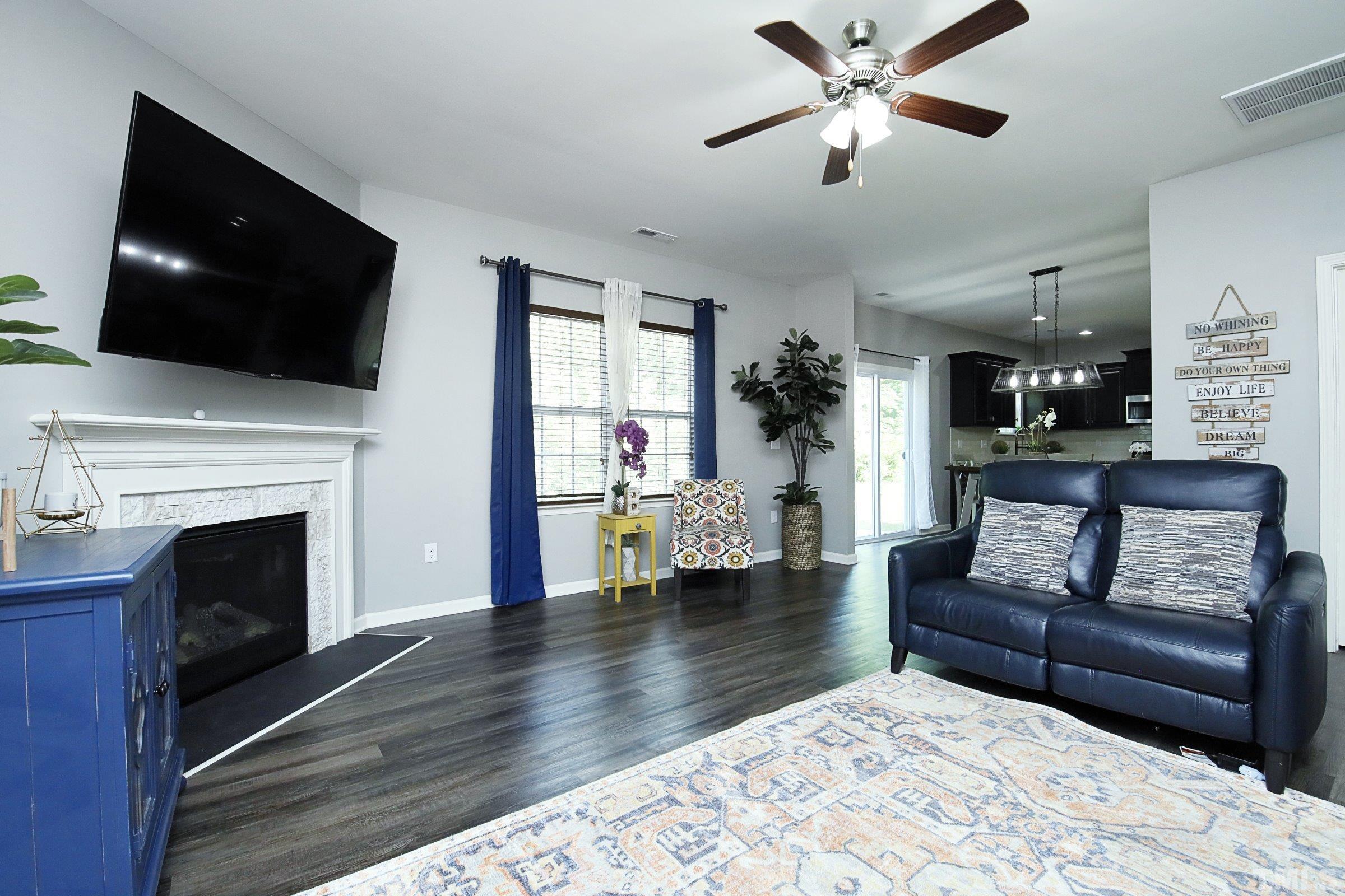 3617 Waleback Lane Raleigh, NC 27610 - Photo 10 of 34 a living room with furniture a fireplace and a flat screen tv