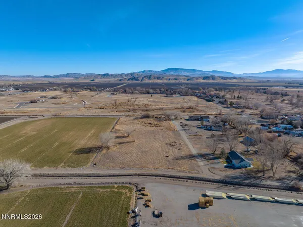 a view of a dry yard with wooden fence