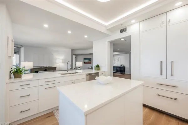 a large white kitchen with sink and cabinets