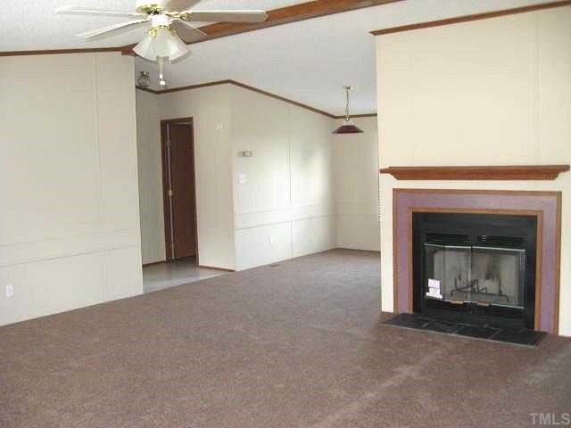 2585 Lucy Garrett Road Timberlake, NC 27583 - Photo 2 of 12 a view of empty room with fireplace and fan