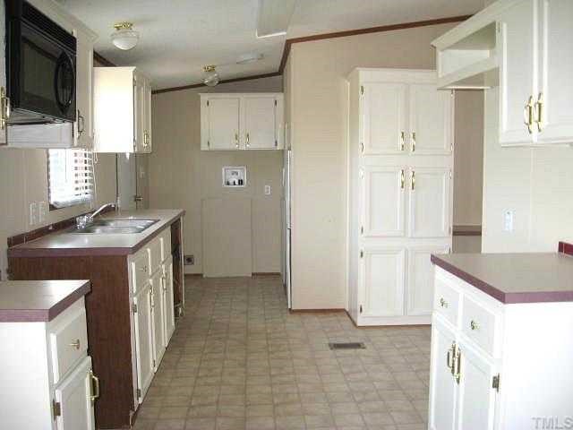 2585 Lucy Garrett Road Timberlake, NC 27583 - Photo 4 of 12 a kitchen with a sink stove and cabinets