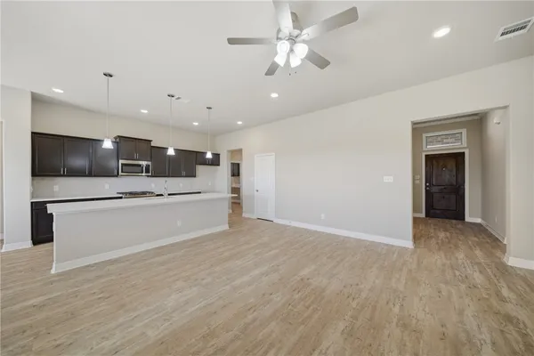 a view of kitchen with microwave and refrigerator