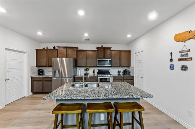 a kitchen with kitchen island a counter space and stainless steel appliances