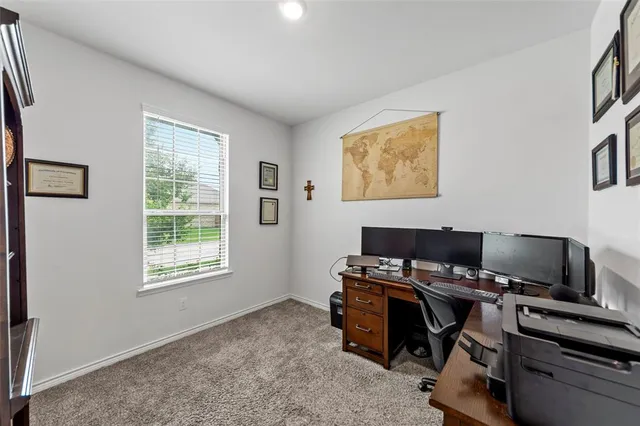 a view of a workspace with furniture and a window