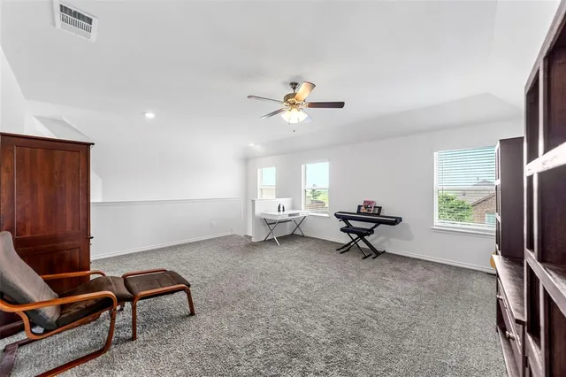 a living room with furniture a ceiling fan and a window
