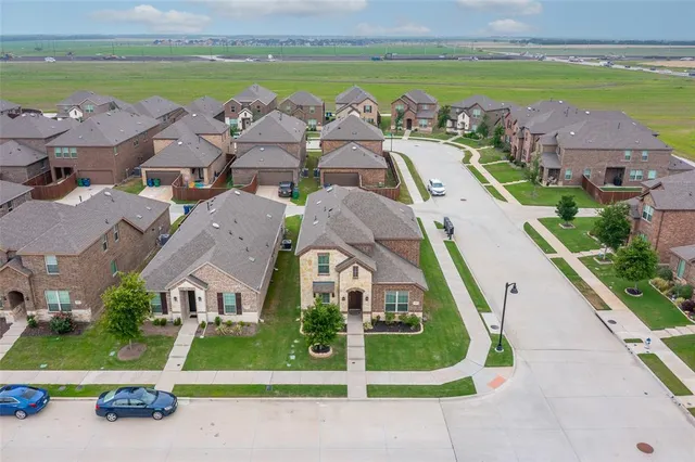 an aerial view of residential houses with outdoor space and ocean view
