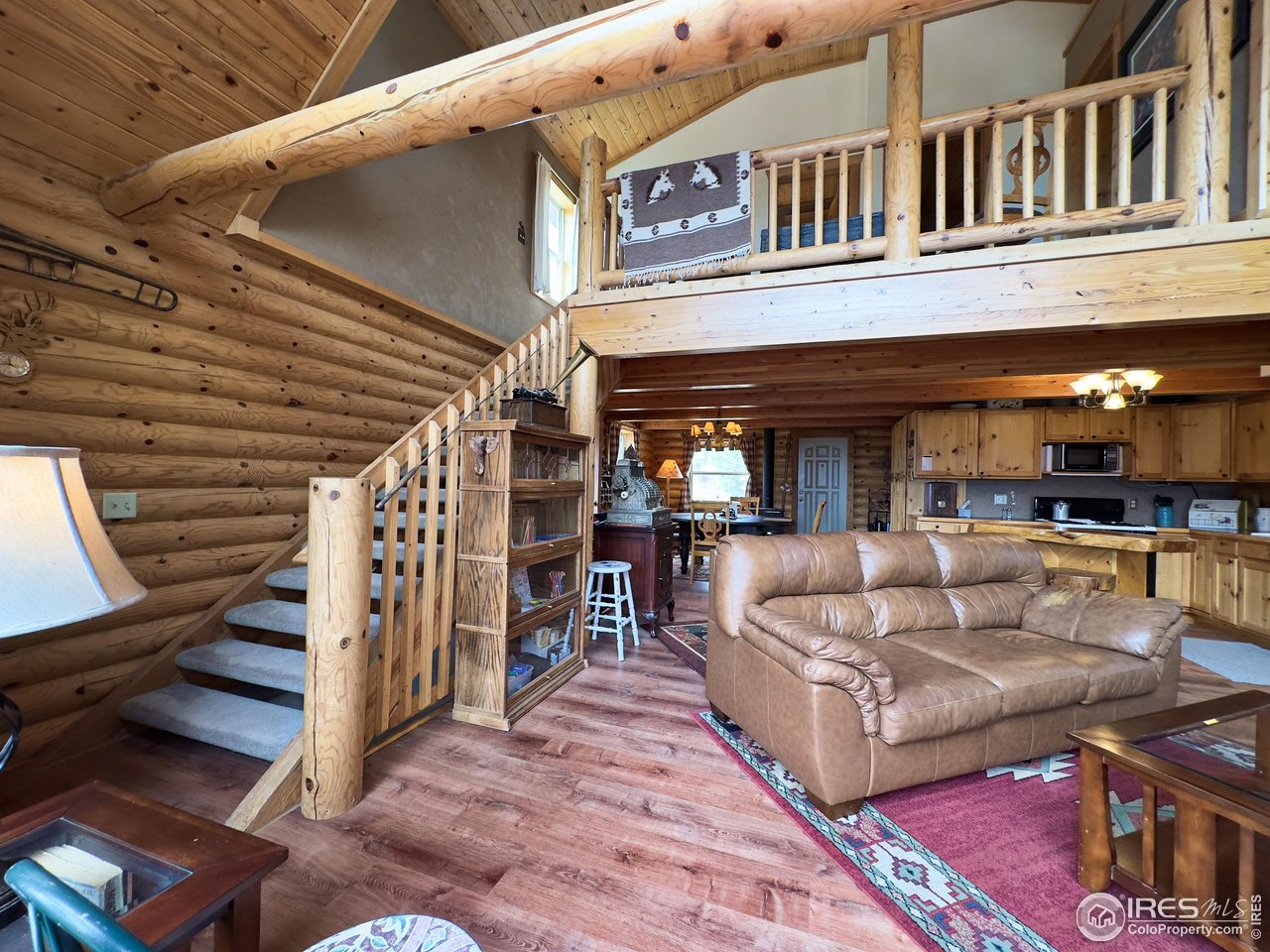 3676 Cherokee Meadows Road Livermore, CO 80536 - Photo 13 of 43 a view of a patio with couches table and chairs with wooden floor