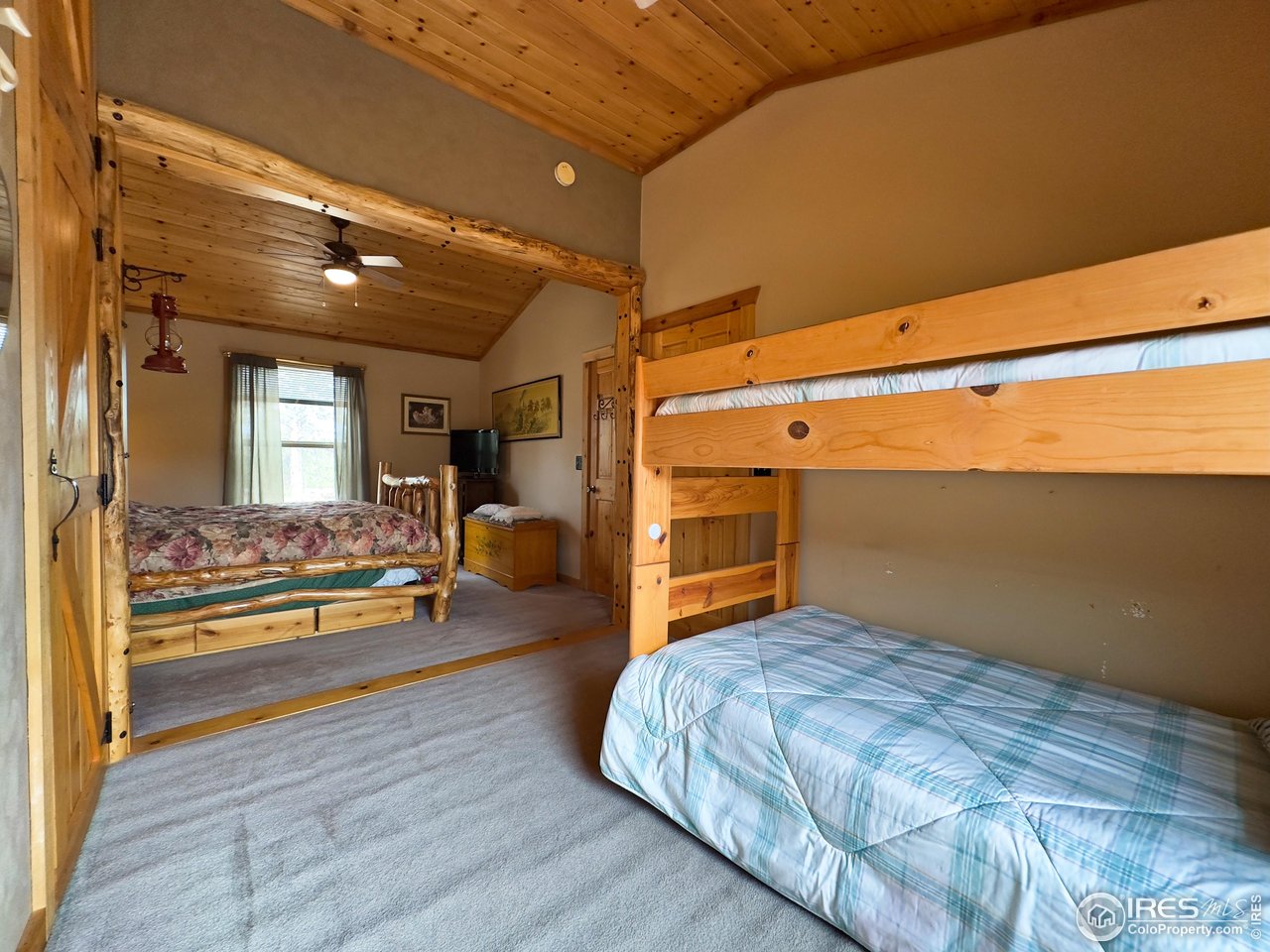 3676 Cherokee Meadows Road Livermore, CO 80536 - Photo 17 of 43 a bedroom with furniture and a wooden floor
