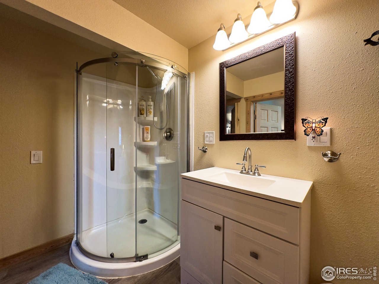 3676 Cherokee Meadows Road Livermore, CO 80536 - Photo 21 of 43 a bathroom with a toilet a sink a mirror and shower