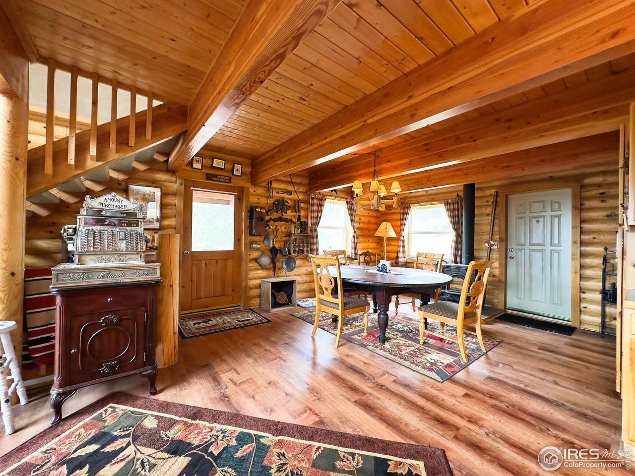 3676 Cherokee Meadows Road Livermore, CO 80536 - Photo 4 of 43 a view of a patio with table and chairs with wooden floor and fence