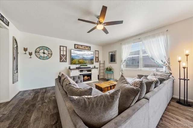 a living room with furniture ceiling fan and a window